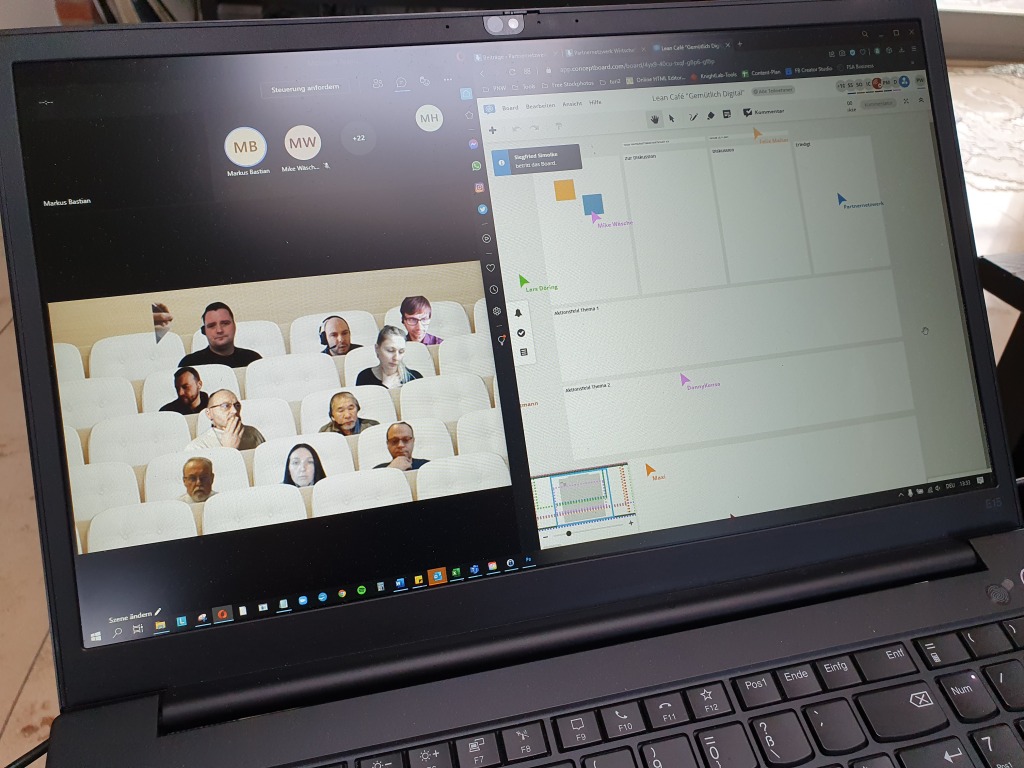 Bildschirm mit Online-Meeting-Teilnehmern und einem virtuellen Whiteboard